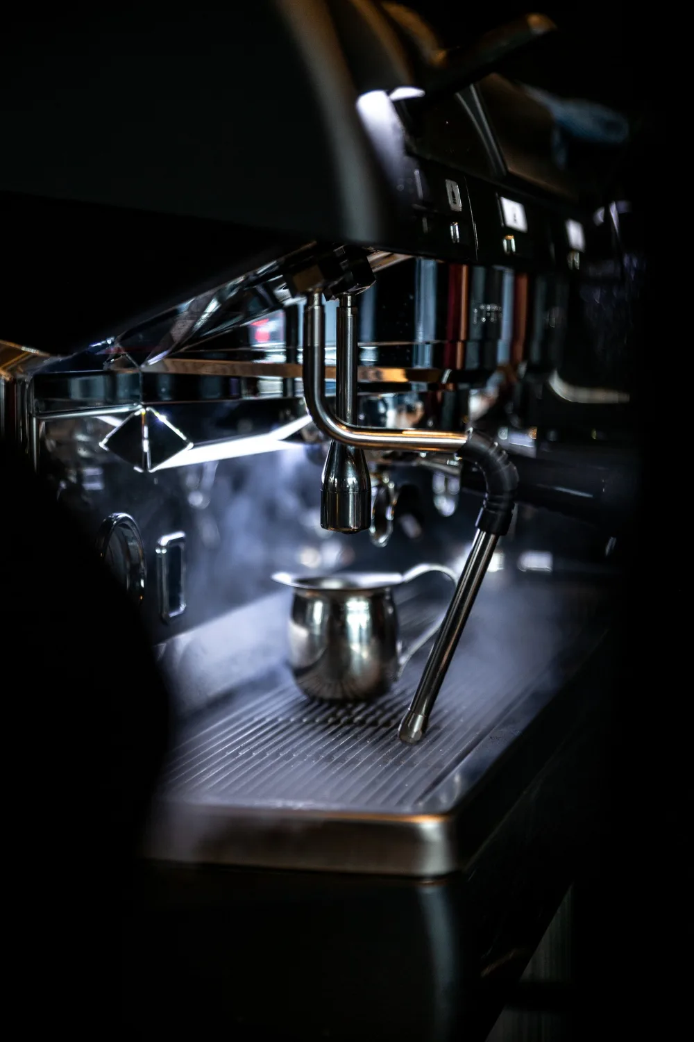 Espressomaskin med mjölkkanna på droppgallret